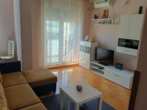 a living room with a couch and a tv and a table at Apartment Andjela in Belgrade