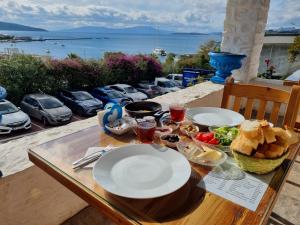 a table with plates of food on it with a view of the ocean at Fethiye Motel BODRUM in Bodrum City