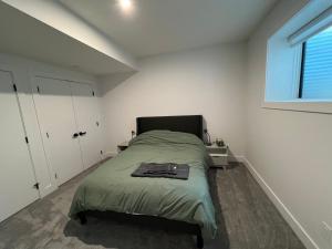 a small bedroom with a bed and a window at NEW Modern and Bright Suite near WEM in Edmonton