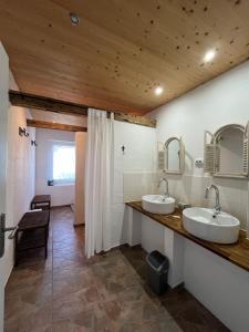 ein Badezimmer mit zwei Waschbecken und einer Holzdecke in der Unterkunft Störtebeker Hof Pension in Pruchten