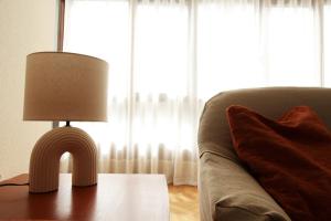 - un salon avec un canapé et une lampe sur une table dans l'établissement Apartamento Brisa Marina, à Suances