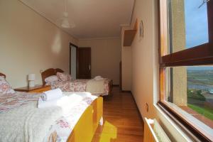 - une chambre avec 2 lits et une grande fenêtre dans l'établissement Apartamento Brisa Marina, à Suances