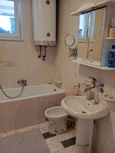 y baño con lavabo, aseo y bañera. en Apartman Sekulić, en Sombor