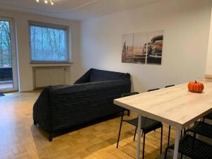ein Wohnzimmer mit einem schwarzen Sofa und einem Tisch in der Unterkunft Exclusive Ferienwohnung Monteurwohnung 8 Personen in Oberhausen