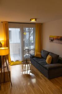 salon z kanapą i dużym oknem w obiekcie Danube City Lodge, uptown, A/C w Wiedniu