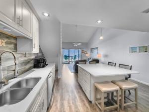 a kitchen with white cabinets and a sink and a counter at Laguna Lookout in Panama City Beach