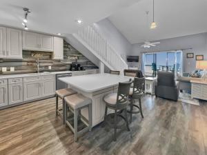 a kitchen with white cabinets and a table and chairs at Laguna Lookout in Panama City Beach