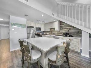 a kitchen with a white table and chairs at Laguna Lookout in Panama City Beach