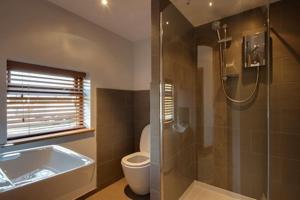 a bathroom with a tub and a toilet and a shower at Bramble, luxury in idyllic setting, at Hollambys in Groombridge