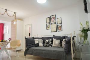 sala de estar con sofá y almohadas en Apartamento Ágüelos, en Madrid