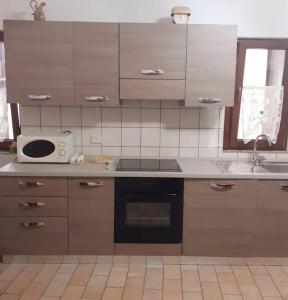 een keuken met een fornuis en een magnetron op een aanrecht bij Casa Il girasole in Boccheggiano