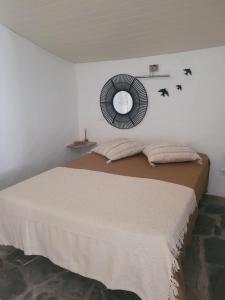 a bedroom with a bed with a mirror on the wall at Estúdio Tia Anica in Reguengos de Monsaraz