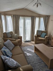 a living room with two couches and a table at Sea Shore Chalet - Rockley Park in Lytchett Minster