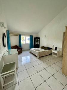 1 dormitorio con 1 cama y suelo de baldosa en LD36 - 3 Bedroom Apartment in Flic En Flac - 3mins from beach, en Flic en Flac