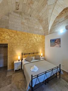 een slaapkamer met een bed en een stenen muur bij B&b Ètoile Salento in Arnesano