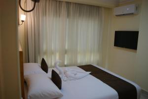 Palm Inn City Hotel في الغردقة: غرفة فندق عليها سرير وبجعة