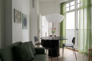 a living room with a table and a green couch at Latin Quarter by Daniel&Jacob's in Copenhagen