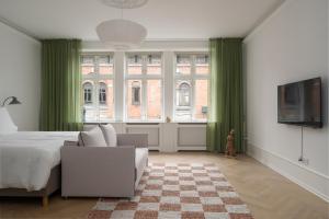 Latin Quarter by Daniel&Jacob's في كوبنهاغن: غرفة نوم مع ستائر خضراء وسرير وتلفزيون