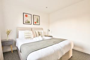 a bedroom with a large bed with white sheets and pillows at StayRight 3 Bed House with Private Parking in Cardiff