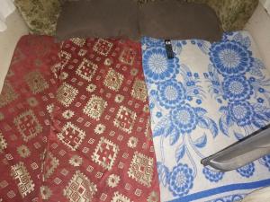バンコクにあるCaravan have TV & Netflixの毛布の上に2枚のスカーフが座っている
