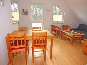 - un salon avec une table, des chaises et un canapé dans l'établissement Apartment house, Trassenheide, à Trassenheide