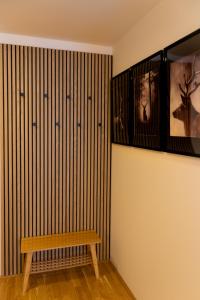 un banco de madera en una habitación con una pared en Danube City Lodge, uptown, A/C, en Viena