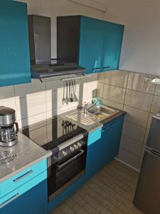 uma cozinha com armários azuis, um fogão e um lavatório em Studio für 2 Personen 1 Kind ca 32 qm in Rab - Barbat, Kvarner Bucht Rab - b52326 em Rab