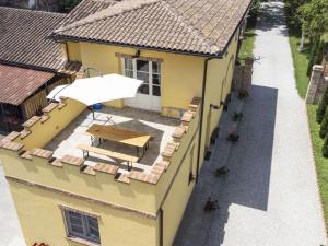 una vista aérea de un edificio amarillo con una mesa de picnic en La casa in toscana en Foiano della Chiana