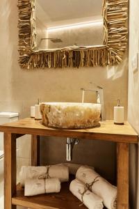 een badkamer met een wastafel, een spiegel en handdoeken bij LUPERCAS in Merida