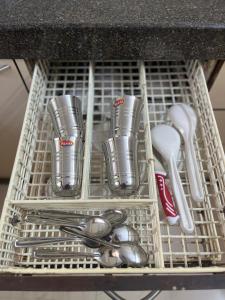 a dish rack with utensils in a sink at Classy & Cozy 1BHK @ Ville Parle Mumbai in Mumbai