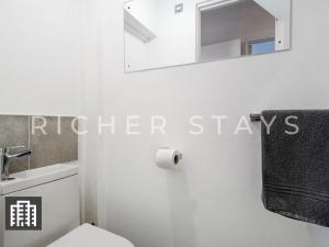 y baño con aseo blanco y espejo. en Watford Large 5BR Home - Contractors & Families en Watford