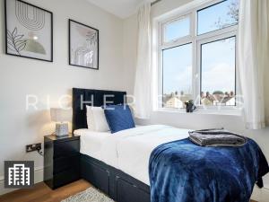 una camera con letto e finestra di Watford Large 5BR Home - Contractors & Families a Watford