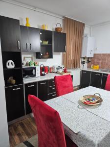 a kitchen with a table and red chairs in it at Sol apartaments 3 camere in Târgu-Mureş