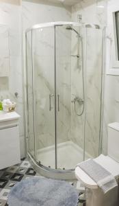 y baño con ducha y puerta de cristal. en Delta - Central Elegant Apartment, en Katerini