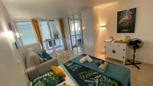 een woonkamer met een bed en een bank bij Anse des Rochers BRIND'ILE charmant appartement, vue mer 50 m plage 2 étoiles Atout France in Saint-François