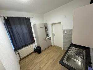 una pequeña cocina con fregadero y nevera. en 3 Schlafzimmer Apartment, en Euratsfeld