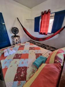 1 dormitorio con edredón en la cama y hamaca en Canto da Sereia., en Soure