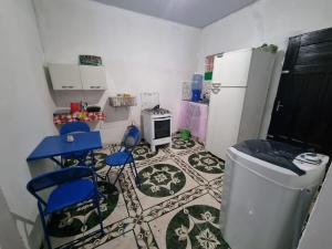 a kitchen with two blue chairs and a refrigerator at Canto da Sereia. in Soure