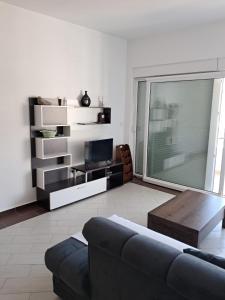 een woonkamer met een bank en een tv bij Belveder Montenegro in Rafailovici
