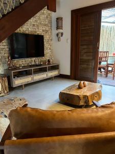 a living room with a couch and a tv at Vila Tamarindo (Bangalô 6) in Barra Grande