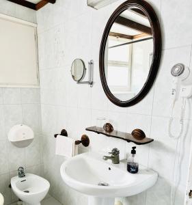 a white bathroom with a sink and a mirror at New Roser in L'Escala
