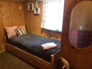 a bed in a wooden cabin with a window at Chalet Mex 15 in Saint-Maurice