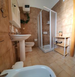 y baño con aseo, lavabo y ducha. en Villa La Sosta - 150m dal mare - Patio Privato e Areal Relax, en Arenella