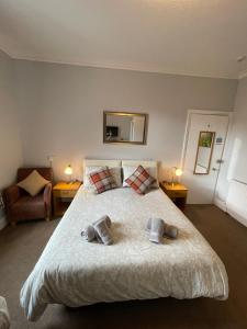 een slaapkamer met een groot bed en 2 handdoeken bij Rivendell Guest House in Keswick