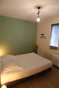 a bedroom with a bed and a green wall at Les oiseaux de la Slack in Ambleteuse