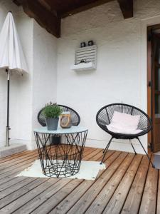 a patio with two chairs and a table and an umbrella at Ferienhaus Bad Feilbach in Bad Feilnbach