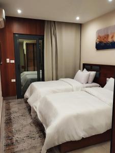 a bedroom with two beds and a mirror at Zahira Pyramids View in Cairo