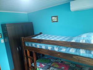 una camera con letto a castello in legno e pareti blu di Espléndida casa a 3 cuadras de la Playa Santa Ana Canelones a Cuchilla Alta