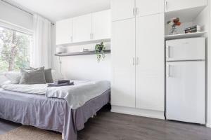 um quarto com uma cama e armários brancos em Studio Hätilänkatu em Hämeenlinna
