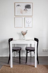 uma mesa branca com duas cadeiras e um vaso com flores em Studio Hätilänkatu em Hämeenlinna